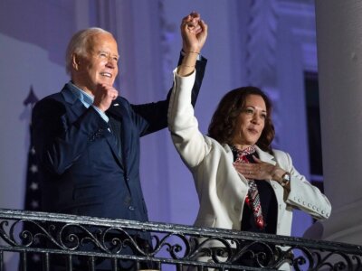 President Joe Biden raises the hand of Vice President Kamala Harris after viewing the Independence Day fireworks display over the National Mall from the balcony of the White House, Thursday, July 4, 2024, in Washington. (AP Photo/Evan Vucci)